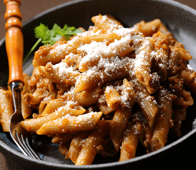 Recipe image Penne Rigate trigo entero Barilla® en salsa genovesa, chamorro de res con cebolla orgánica y queso parmesano.